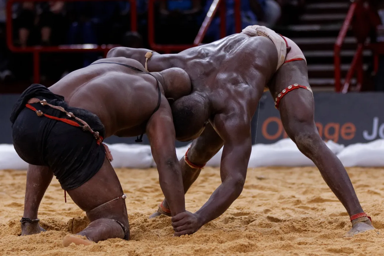 Lottatori di lutte sénégalaise in combattimento tradizionale sulla sabbia
