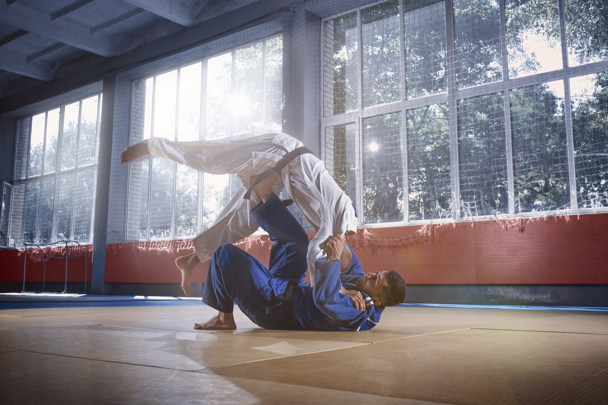 Two judokas practicing a throw on the mat